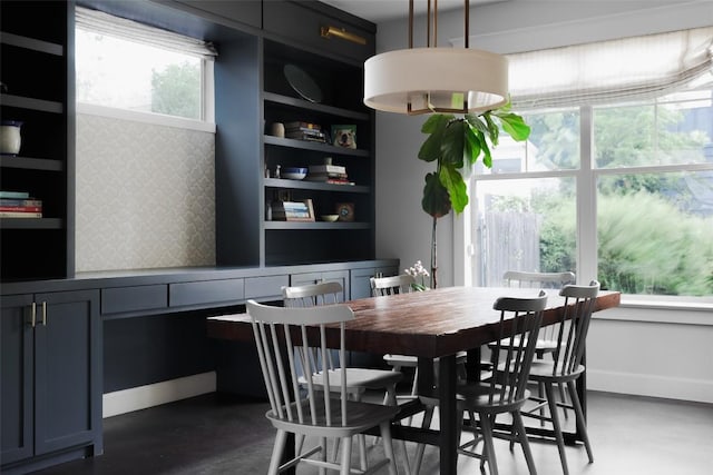 dining area with finished concrete floors and baseboards