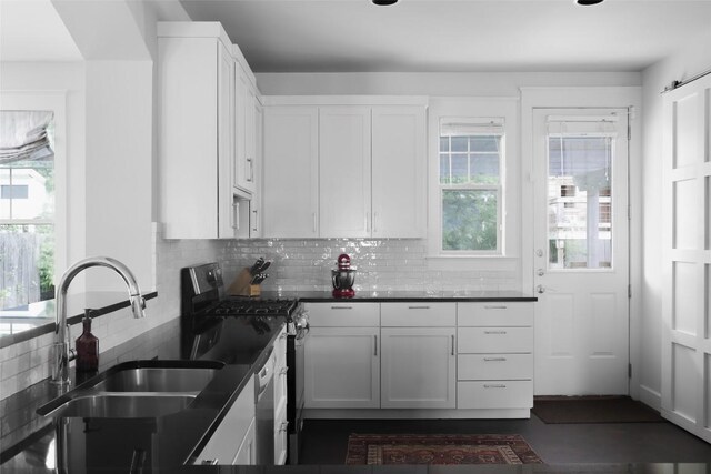 5607 Roosevelt Ave, Austin, TX 78756 - kitchen with gas stove, decorative backsplash, dark countertops, and white cabinetry