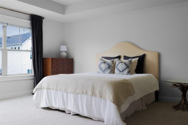 carpeted bedroom featuring multiple windows and baseboards
