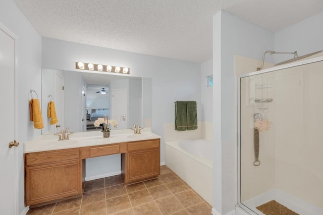 16914 Dorman Dr, Round Rock, TX 78681 - bathroom with a stall shower, a bath, double vanity, ceiling fan, and a textured ceiling