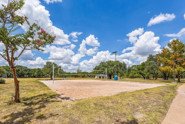 view of home's community featuring volleyball court and a lawn