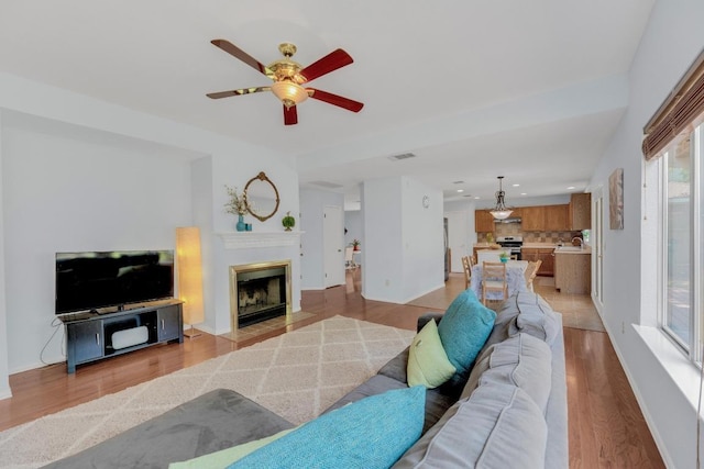 16914 Dorman Dr, Round Rock, TX 78681 - living room with a fireplace, a ceiling fan, light wood finished floors, and recessed lighting