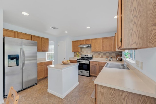 16914 Dorman Dr, Round Rock, TX 78681 - kitchen with stainless steel appliances, under cabinet range hood, light countertops, a center island, and backsplash