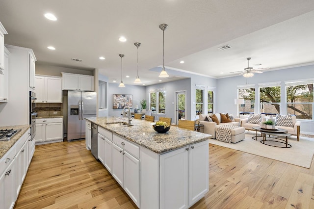 8317 Turning Trl, Austin, TX 78737 - kitchen with stainless steel appliances, a sink, light wood-type flooring, white cabinets, and recessed lighting
