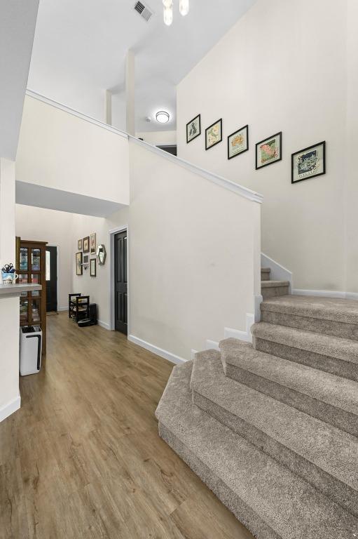 605 Galway Bay Cv, Pflugerville, TX 78660 - stairs featuring a high ceiling, wood finished floors, and baseboards