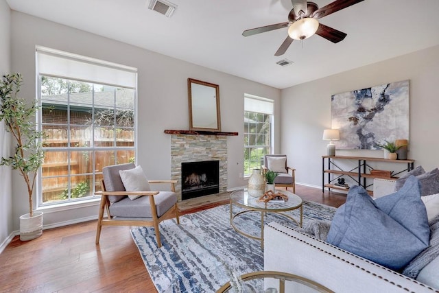 3831 Epperson Trl, Austin, TX 78732 - living area with ceiling fan, a stone fireplace, wood finished floors, and baseboards