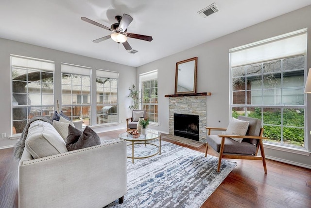 3831 Epperson Trl, Austin, TX 78732 - living room featuring a stone fireplace, a ceiling fan, wood finished floors, and baseboards
