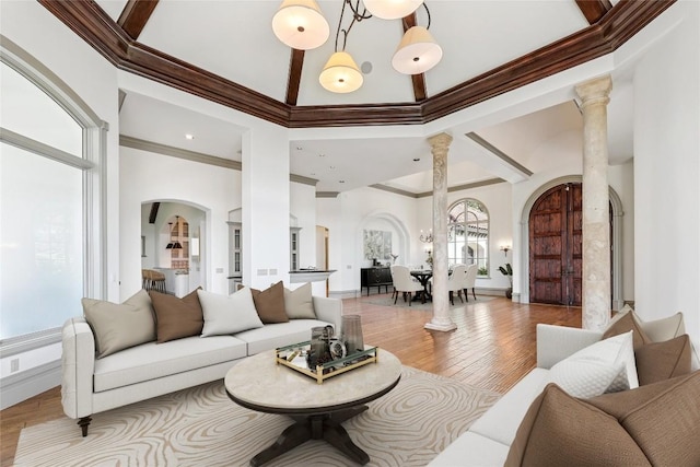 16010 Canard Cir, Austin, TX 78734 - living area featuring arched walkways, decorative columns, a towering ceiling, wood finished floors, and crown molding