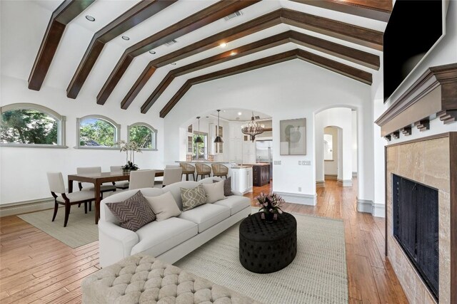16010 Canard Cir, Austin, TX 78734 - living area featuring arched walkways, healthy amount of natural light, a chandelier, and light wood-style flooring