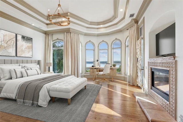 16010 Canard Cir, Austin, TX 78734 - bedroom featuring ornamental molding, a tray ceiling, a glass covered fireplace, a chandelier, and an office area