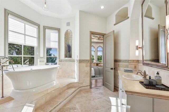 16010 Canard Cir, Austin, TX 78734 - full bathroom featuring a freestanding tub, vanity, ensuite bathroom, tile walls, and a wainscoted wall