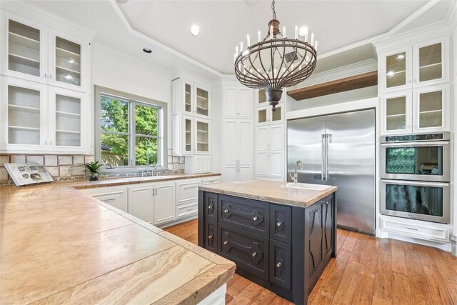 16010 Canard Cir, Austin, TX 78734 - kitchen with stainless steel appliances, dark cabinets, white cabinetry, a chandelier, and ornamental molding