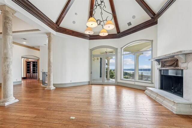 16010 Canard Cir, Austin, TX 78734 - unfurnished living room with decorative columns, high vaulted ceiling, a fireplace with raised hearth, beam ceiling, and light wood finished floors