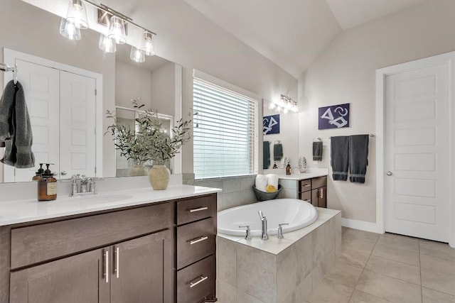 321 Millard St, Georgetown, TX 78628 - bathroom with lofted ceiling, two vanities, a garden tub, and tile patterned floors