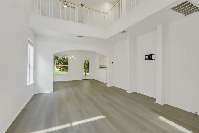 10312 Laredo Dr Unit 165, Austin, TX 78748 - unfurnished living room featuring a towering ceiling, arched walkways, and wood finished floors