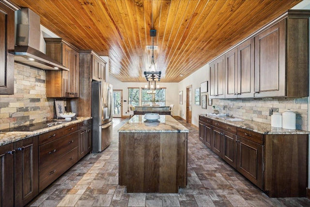 20603 Ridgeview Rd, Lago Vista, TX 78645 - kitchen featuring freestanding refrigerator, wall chimney exhaust hood, wood ceiling, a kitchen island, and black electric stovetop