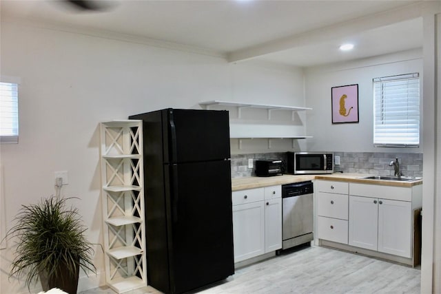 24701 Martin Ln, Spicewood, TX 78669 - kitchen with appliances with stainless steel finishes, open shelves, decorative backsplash, white cabinetry, and light wood finished floors