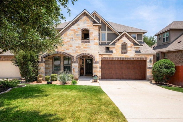 5517 Brady Bayou Cv, Austin, TX 78738 - view of front of house with stone siding, a front lawn, concrete driveway, an attached garage, and roof with shingles