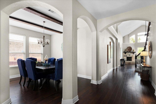 5517 Brady Bayou Cv, Austin, TX 78738 - dining room with a fireplace, dark wood-style floors, a chandelier, a ceiling fan, and arched walkways