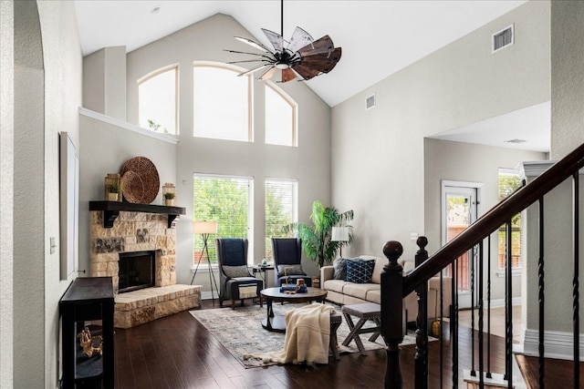 5517 Brady Bayou Cv, Austin, TX 78738 - living area featuring dark wood-type flooring, high vaulted ceiling, a stone fireplace, and stairs