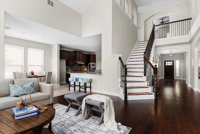 5517 Brady Bayou Cv, Austin, TX 78738 - living area featuring a ceiling fan, hardwood / wood-style flooring, arched walkways, stairway, and a high ceiling
