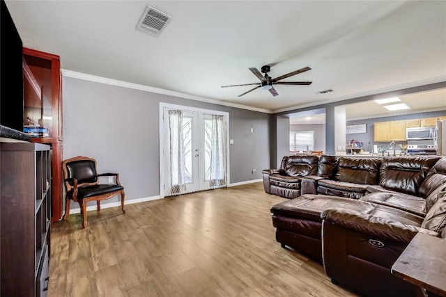2718 Georgian Dr, Georgetown, TX 78626 - living room featuring ornamental molding, baseboards, french doors, ceiling fan, and light wood finished floors