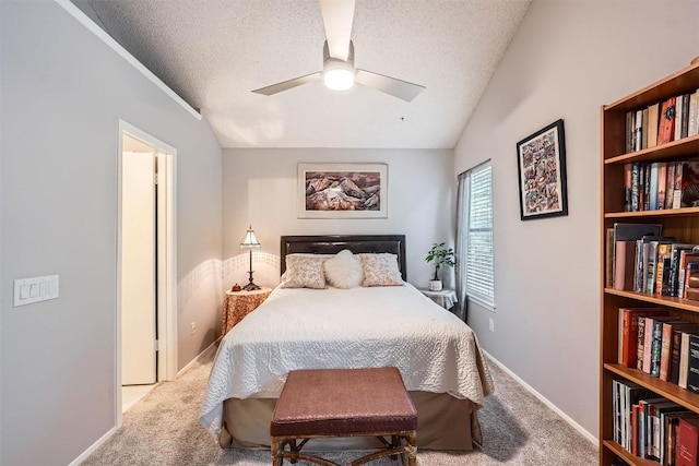 bedroom featuring carpet flooring, a textured ceiling, baseboards, a ceiling fan, and vaulted ceiling