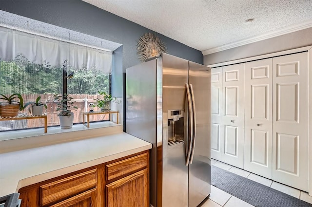 11901 Swearingen Dr Unit 30, Austin, TX 78758 - kitchen featuring stainless steel fridge with ice dispenser, light tile patterned floors, brown cabinets, a textured ceiling, and light countertops
