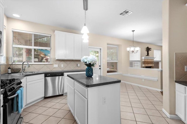 2502 Nightshade Dr, Cedar Park, TX 78613 - kitchen featuring stainless steel dishwasher, black range with gas stovetop, dark countertops, and a sink