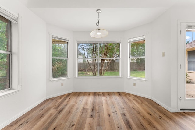 unfurnished dining area featuring light wood finished floors and baseboards