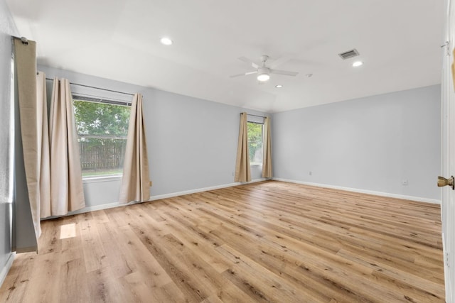 empty room featuring healthy amount of natural light, ceiling fan, light wood-style flooring, recessed lighting, and baseboards