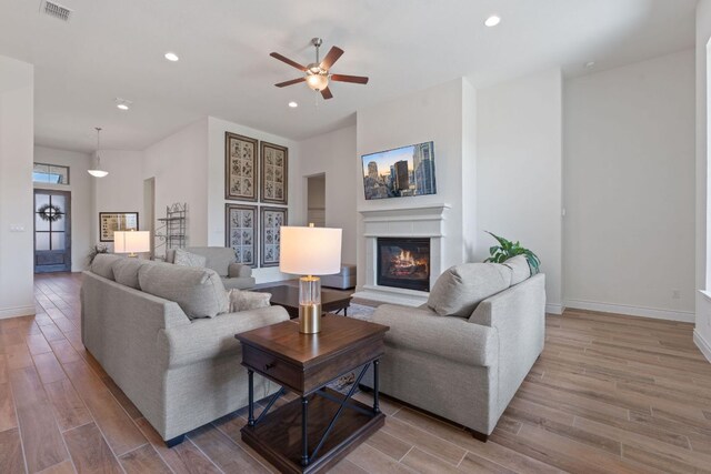 1437 Argyll Park, Bulverde, TX 78163 - living room with wood finished floors, ceiling fan, a glass covered fireplace, recessed lighting, and baseboards