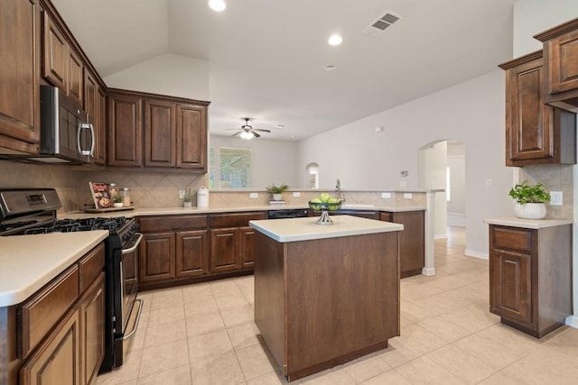 765 Bent Wood Pl, Round Rock, TX 78665 - kitchen with appliances with stainless steel finishes, arched walkways, a peninsula, a ceiling fan, and tasteful backsplash