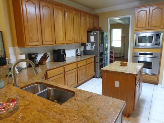 4003 Wyman Cv, Round Rock, TX 78681 - kitchen with stainless steel appliances, a sink, light stone counters, crown molding, and light tile patterned flooring