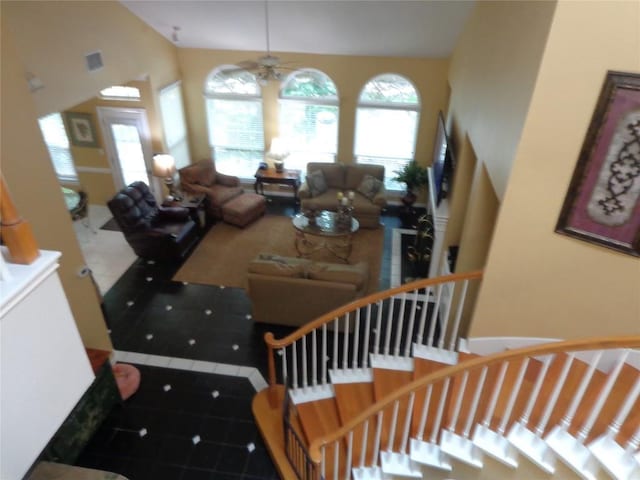 4003 Wyman Cv, Round Rock, TX 78681 - tiled living room with healthy amount of natural light, a ceiling fan, lofted ceiling, and stairway