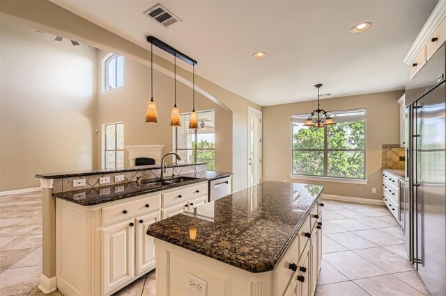 205 Sebastians Run, Austin, TX 78738 - kitchen featuring a center island, dishwashing machine, dark stone counters, decorative light fixtures, and recessed lighting