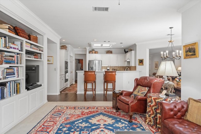 259 Red Poppy Trl, Georgetown, TX 78633 - living room featuring crown molding, a chandelier, recessed lighting, and built in shelves