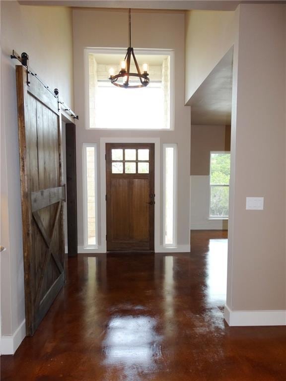 20601 Branding Iron, Lago Vista, TX 78645 - entrance foyer featuring a barn door, a chandelier, baseboards, and a high ceiling