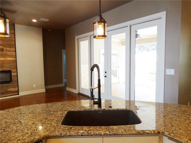 20601 Branding Iron, Lago Vista, TX 78645 - kitchen featuring a sink, wood finished floors, light stone counters, decorative light fixtures, and recessed lighting