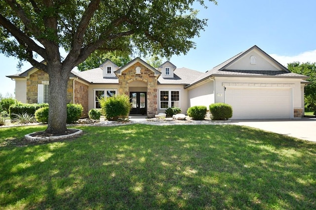 115 Blazing Star Dr, Georgetown, TX 78633 - view of front of home with stone siding, a garage, french doors, a front lawn, and concrete driveway