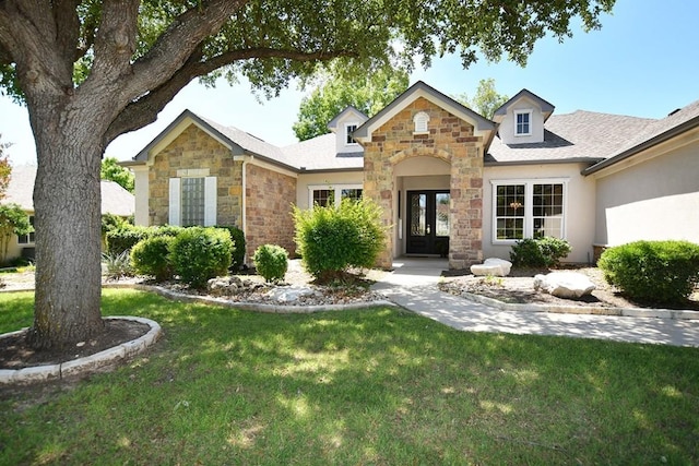 115 Blazing Star Dr, Georgetown, TX 78633 - traditional-style house with stone siding, a front lawn, french doors, and stucco siding