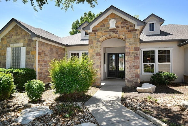 115 Blazing Star Dr, Georgetown, TX 78633 - property entrance featuring french doors, stone siding, a shingled roof, and stucco siding