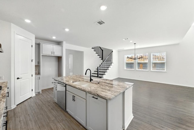kitchen with a sink, dark wood finished floors, a center island with sink, a chandelier, and recessed lighting
