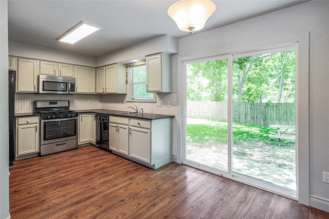 16213 Malden Dr, Pflugerville, TX 78660 - kitchen with appliances with stainless steel finishes, dark countertops, backsplash, and dark wood-style flooring