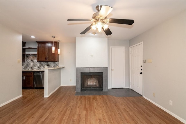 3115 Helms St Unit 115, Austin, TX 78705 - unfurnished living room with dark wood-type flooring, ceiling fan, and a tile fireplace