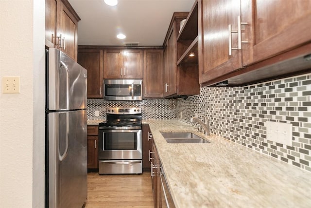 3115 Helms St Unit 115, Austin, TX 78705 - kitchen with stainless steel appliances, tasteful backsplash, light wood-type flooring, light stone countertops, and open shelves