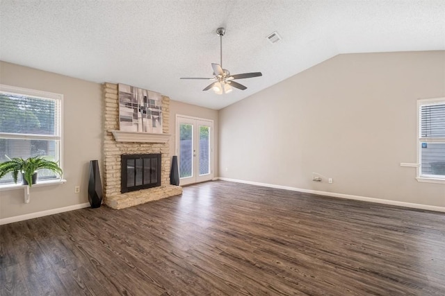 7503 Islander Dr, Austin, TX 78749 - unfurnished living room with a ceiling fan, vaulted ceiling, dark wood finished floors, a textured ceiling, and a fireplace
