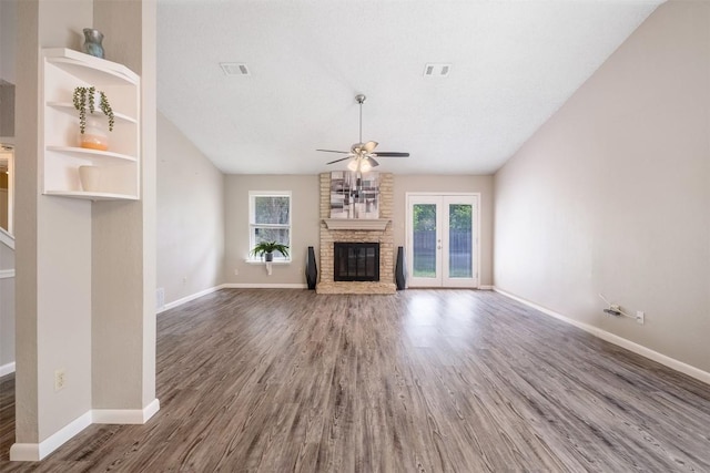 7503 Islander Dr, Austin, TX 78749 - unfurnished living room with ceiling fan, plenty of natural light, a stone fireplace, and wood finished floors