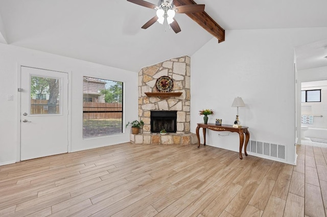 5406 Fence Row, Austin, TX 78744 - living room featuring ceiling fan, light wood-style floors, a stone fireplace, and healthy amount of natural light