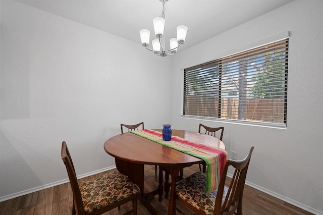 dining area with a chandelier, wood finished floors, and baseboards